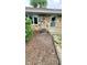 Rear exterior showcasing brick, air conditioning unit and access door surrounded by mulch bed at 3702 Candy Cane Dr, Indianapolis, IN 46227