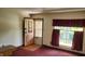 Bright living room with large window, carpet, and a glass-paneled front door at 3702 Candy Cane Dr, Indianapolis, IN 46227