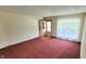 A cozy living room with carpet, a front door, and a window with natural light at 3702 Candy Cane Dr, Indianapolis, IN 46227