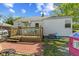Charming backyard featuring a wooden deck, patio, and lush greenery; ideal for outdoor living and entertaining at 376 S Arlington Ave, Indianapolis, IN 46219