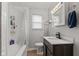 Well-lit bathroom with a modern vanity, tiled bathtub, and stylish fixtures at 376 S Arlington Ave, Indianapolis, IN 46219
