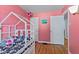 Pink bedroom featuring hardwood floors and a playful house-frame bed at 376 S Arlington Ave, Indianapolis, IN 46219
