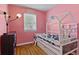 Adorable pink bedroom with a house-frame bed and decorative wall art at 376 S Arlington Ave, Indianapolis, IN 46219