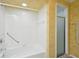 Well-lit bathroom featuring a shower-tub combination with accessibility features and tiled walls at 410 Sugar Tree Ln, Indianapolis, IN 46260