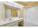 Bright bathroom featuring a spacious vanity, a large mirror, and a shower-tub combination at 410 Sugar Tree Ln, Indianapolis, IN 46260