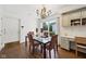 Bright dining area features hardwood floors, chandelier, and a glass table for contemporary elegance at 410 Sugar Tree Ln, Indianapolis, IN 46260