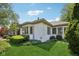 Charming home featuring a well-manicured lawn, lush landscaping, and a bright, white brick exterior at 410 Sugar Tree Ln, Indianapolis, IN 46260