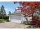 Detached garage with a clean white door, surrounded by a neatly paved driveway and mature landscaping at 410 Sugar Tree Ln, Indianapolis, IN 46260