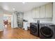 Convenient laundry room with modern washer, dryer, utility sink and ample cabinet storage space at 410 Sugar Tree Ln, Indianapolis, IN 46260