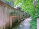 Wood fence and a path surrounded by mature trees create a private and peaceful walkway at 4268 Foxglove Trce, Indianapolis, IN 46237
