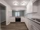 Modern kitchen with white cabinets, granite countertops, stainless steel appliances, and wood-look floors at 4268 Foxglove Trce, Indianapolis, IN 46237