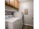 Functional laundry room with washer, dryer, and upper cabinetry at 4268 Foxglove Trce, Indianapolis, IN 46237