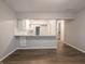 Open-concept living area featuring wood-look floors and a breakfast bar leading to the kitchen at 4268 Foxglove Trce, Indianapolis, IN 46237