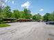 Community parking lot with covered parking and lots of mature trees on a sunny day at 4268 Foxglove Trce, Indianapolis, IN 46237