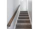 Carpeted staircase with wooden handrail for an aesthetically pleasing, safe climb at 4268 Foxglove Trce, Indianapolis, IN 46237