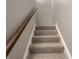 Carpeted stairway with wooden railing at 4268 Foxglove Trce, Indianapolis, IN 46237