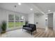 Finished basement area with a modern sofa, large windows offering natural light, and wood-look floors at 450 Pleasant St, Noblesville, IN 46060