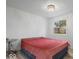 Bright bedroom featuring a red bedspread, hardwood floors, and a modern light fixture at 450 Pleasant St, Noblesville, IN 46060