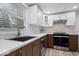 Modern kitchen featuring white cabinets, stainless steel sink, and wood-look flooring at 450 Pleasant St, Noblesville, IN 46060