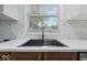 Well-lit kitchen sink with modern faucet, view to outside and white quartz counters at 450 Pleasant St, Noblesville, IN 46060