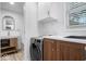 Modern laundry room with white shaker cabinets, quartz countertops, and stainless steel washer at 450 Pleasant St, Noblesville, IN 46060