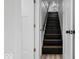 Stairwell featuring carpeted stairs and a white door at 450 Pleasant St, Noblesville, IN 46060