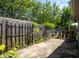 Cement back patio area surrounded by a wooden fence, green growth, and a wooden gate at 4625 N Sadlier Dr, Indianapolis, IN 46226