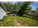 This backyard features an overgrown lawn and mature trees at 4625 N Sadlier Dr, Indianapolis, IN 46226
