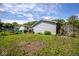 Backyard featuring an overgrown lawn, shed, and mature trees at 4625 N Sadlier Dr, Indianapolis, IN 46226