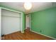 Bedroom featuring green walls, laminate floors, a closet, and natural light at 4625 N Sadlier Dr, Indianapolis, IN 46226