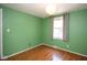 This bedroom features green walls, laminate floors, and natural light at 4625 N Sadlier Dr, Indianapolis, IN 46226