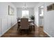 Elegant dining room featuring wood floors, wainscoting, modern lighting, and a view of the backyard, perfect for gatherings at 469 Ash Dr, Carmel, IN 46032