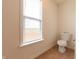 Small bathroom featuring tile flooring, a toilet and a window at 4712 Clairmont Dr, Columbus, IN 47203