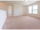 A bright bedroom with carpet flooring and a large window providing plenty of natural light at 4712 Clairmont Dr, Columbus, IN 47203