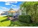 Exterior view of the backyard with a brick patio, seating, lush lawn, mature trees and blue sky at 4824 Eagles Watch Ln, Indianapolis, IN 46254