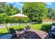 The backyard patio has an umbrella, seating, firepit, and a large grassy lawn at 4824 Eagles Watch Ln, Indianapolis, IN 46254