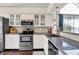 Well-lit kitchen with stainless steel appliances, white cabinets, and modern countertops at 4824 Eagles Watch Ln, Indianapolis, IN 46254