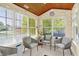 Bright sunroom filled with natural light, modern chairs, and a wood paneled ceiling at 4824 Eagles Watch Ln, Indianapolis, IN 46254