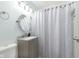 Bright bathroom with a patterned shower curtain, neutral vanity, and a stylish, round mirror at 4967 Diana Dr, Indianapolis, IN 46203