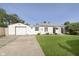 Charming home featuring a detached garage, well-kept lawn, and inviting curb appeal under a clear blue sky at 4967 Diana Dr, Indianapolis, IN 46203