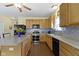 Well-lit kitchen with wooden cabinetry, stone countertops, and a mosaic tile backsplash at 5145 Greenside Dr, Indianapolis, IN 46235