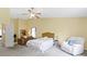 Large main bedroom features a ceiling fan, a seating area and is painted a soft yellow at 5145 Greenside Dr, Indianapolis, IN 46235