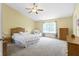 Spacious main bedroom with neutral carpet, a ceiling fan, and a large window at 5145 Greenside Dr, Indianapolis, IN 46235