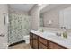 This bathroom features a double sink vanity, tile flooring, and a shower with blue floral curtains at 532 Amersham Ct, Avon, IN 46123