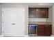 Wet bar featuring a wine cooler, granite counter tops, and dark wood cabinetry at 548 Gosford Ct, Westfield, IN 46074