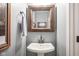 Stylish powder room featuring a pedestal sink, decorative mirror, and modern fixtures at 548 Gosford Ct, Westfield, IN 46074