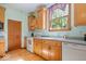 A well-lit kitchen area featuring wooden cabinets, a white oven, and a window over the sink at 5480 E County Rd 800 N, Brownsburg, IN 46112