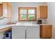 A bright laundry room features a washer, dryer, ample counter space, overhead cabinets, and a large window at 5480 E County Rd 800 N, Brownsburg, IN 46112