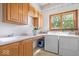 Well-lit laundry room with cabinets, sink, countertop space, and modern washer and dryer at 5480 E County Rd 800 N, Brownsburg, IN 46112