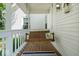Covered porch featuring wood floors, a hanging swing and a rug, creating a cozy outdoor space at 5480 E County Rd 800 N, Brownsburg, IN 46112